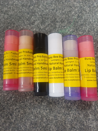 Collection of natural beeswax lip balms with visible labels on a textured surface