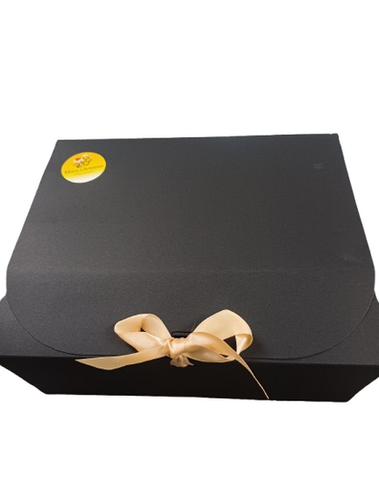 Black gift box with a gold bow and a yellow label on a white background