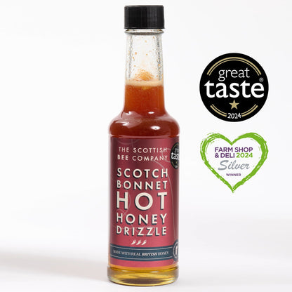 Bottle of Scottish Bee Company Scotch Bonnet Hot Honey Drizzle with awards on a white background