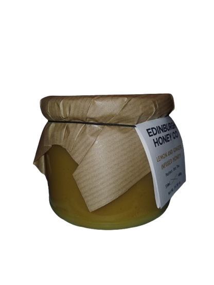Jar of honey with a paper cover and label on a white background