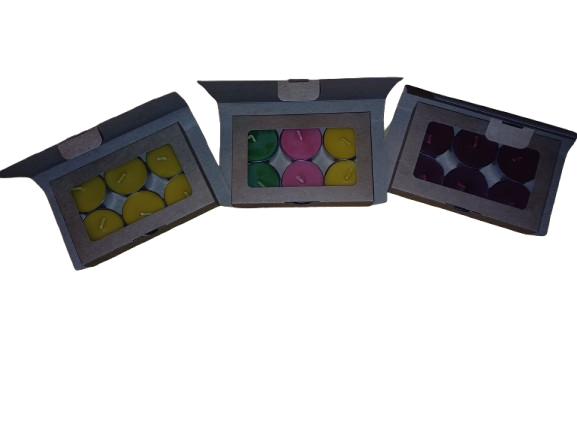 Three open boxes containing colorful  beeswax tealight candles on a white background